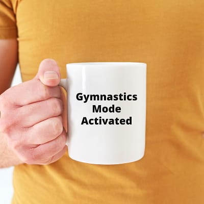 Gymnastics Mode Activated_Man w mustard color tshirt holding 11 oz white mug-800x800